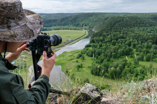 A man takes a picture of beautiful panorama of Belaya river. Bashkiria national park, Bashkortostan, Russia.