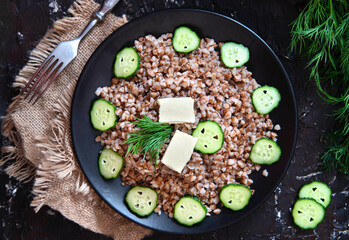 Buckwheat porridge with cucumber and butter. top view.