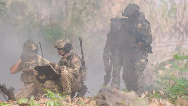 Two soldier look to map and discuss about the way to bring their injury friends to escape from enemy during war. Concept of teamwork and tools help and support for fighting in war.