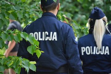 Policjanci na służbie w parku na tle zieleni.  © FotoDax