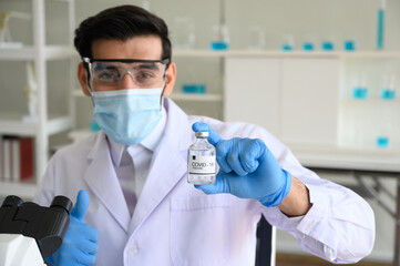 Doctor show vaccine on his hand, covid-19 treatment. The researcher are working to conduct the result in the medical research laboratory.