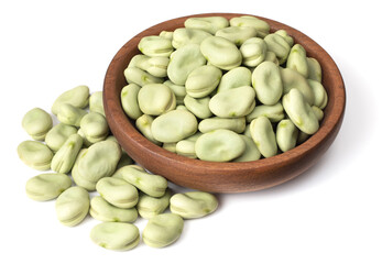 uncooked dried green faba beans in the wooden bowl, isolated on white background