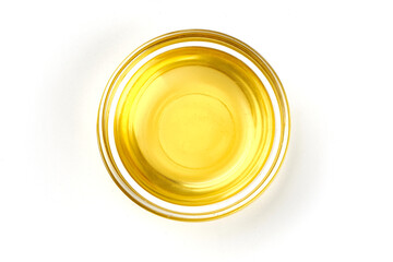 Top view of vegetable or olive oil in a bowl, isolated on white background.
