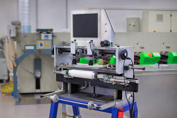 Flexo Plate Mounting Machine in printing hall. Printing press is in the background.