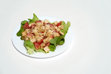 Fried tofu with vegetables and sesame seeds on white plate and whit background, copy space