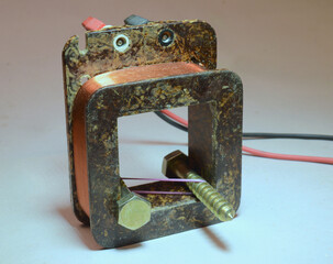 Two screws held together with a rubber band inside a coil. Because current flows in the coil they...