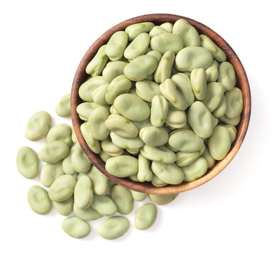 uncooked dried green faba beans in the wooden bowl, isolated on white background, top view