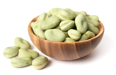 uncooked dried green broad beans in the wooden bowl, isolated on white background