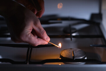 A man going to light a gas stove with a match