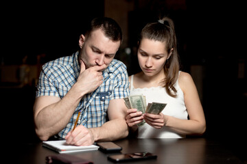 guy and the girl are counting the money and looking thoughtfully