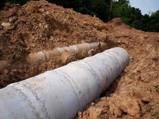 Closeup - new and old concrete drains in the ground. On the ground background on the construction...