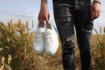 White shoes held in hand