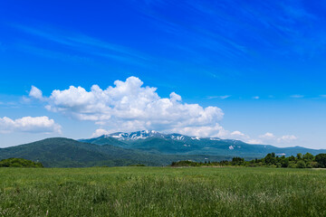 日本　栗駒山 駒姿の残雪と高原の牧場