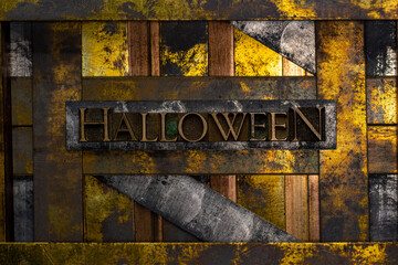 Halloween text formed with real authentic typeset letters on vintage textured silver grunge copper and gold background