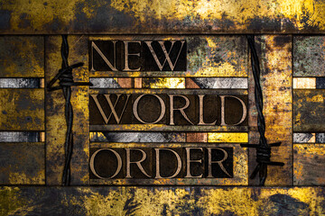 New World Order text formed with real authentic typeset letters on vintage textured silver grunge copper and gold background with barb wire