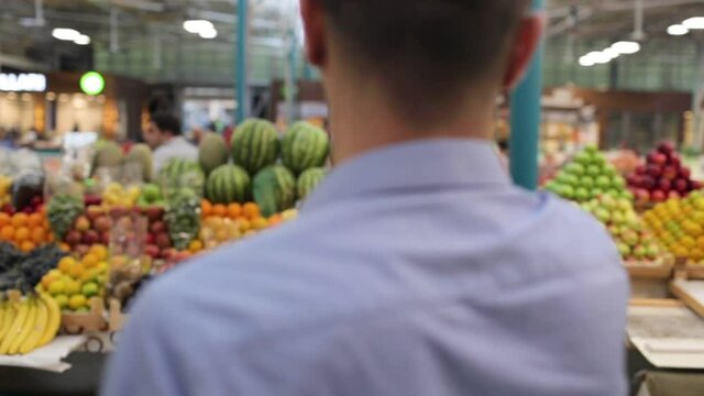 Man takes photo of fruits and vegetables in the local market
