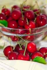 glass bowl with red cherries on yellow tablecloth