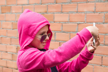 portrait of girl with sunglasses taking a selfie with the mobile phone