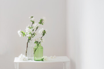 apple flowers in glass vase in white interior