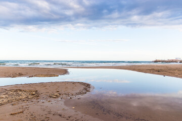 Playa vacia en verano  con reflejo en el agua