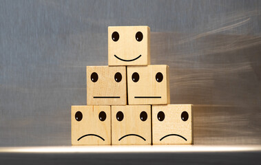 Customer chooses a smiley face on wood cube block, Business service rating , Satisfaction concept