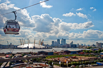 Emirates Air Line cable car travels over the Thames and The O2 Arena Canary Wharf Greenwich London...