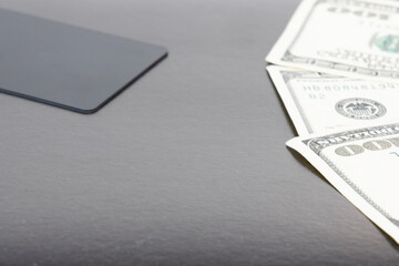Obraz premium advertising pattern of business finance tool credit card and cash money dollars banknotes on stylish gray table simple background surface empty copy space for your text