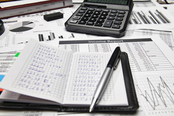 Obraz premium Top view of office employee's desk - work with financial reports, analysis and accounting, tables and graphs, various office items for bookkeeping