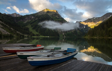 Ruderboote am Vilsalpsee zum Sonnenaufgang im Tannheimer Tal / rowing boats at Vilsalpsee lake in...