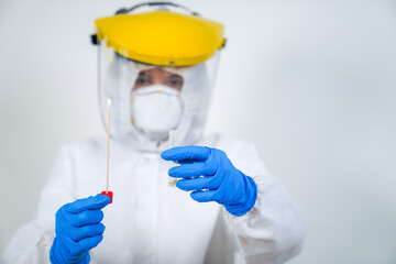 The doctors in the PPE protective suit performed a nasal congestion swab covid from a person to test for the coronavirus covid-19 infection.
