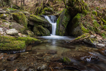 Fototapeta na wymiar little beautiful waterfall with a stonestage an moss