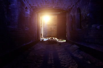 Old ruined brick vaulted tunnel. Dark passage. Underground communication. Light at the end