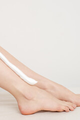 Female nice long slim bare legs with shaving foam on white background