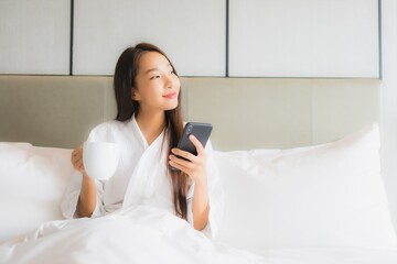 Portrait beautiful young asian woman use smart mobile phone in bedroom