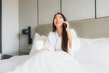 Portrait beautiful young asian woman use smart mobile phone in bedroom