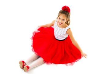 Little girl is sitting on the floor.