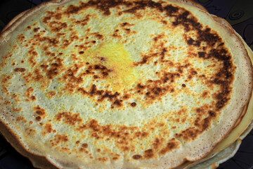 Fried pancakes with butter on a dark background