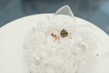 Obraz na płótnie Canvas gold wedding rings lie on a white stand, with a pendant with the inscription love