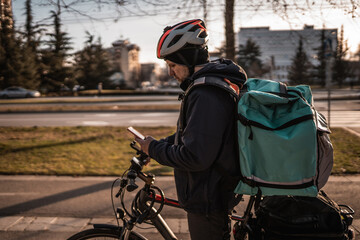 Delivery boy looking for the right direction on mobile phone