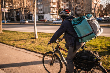 Young man delivering food by bike in the city