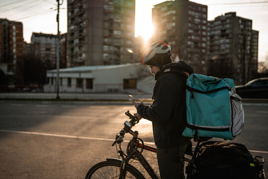 Delivery boy looking for the right direction on mobile phone