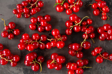 Red currants scattered over a gray texture background