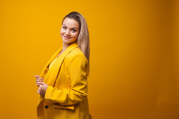 Stylish positive young woman on yellow background, copy space.