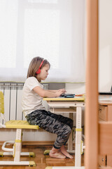 Side view photo of teen boy studying at home during quarantine