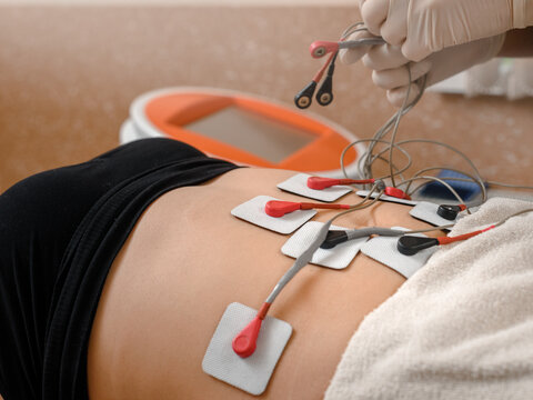 Fat client getting myostimulation procedure for weight loss in beauty salon