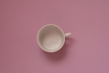 empty white mug with shadow on a pink background.
