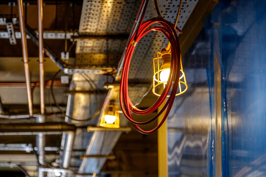 coil of computer network cable hanging from ceiling in front of work light in building under construction