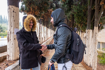 Happy muslim friends shaking hands at university