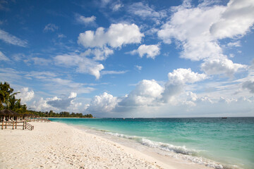 Clean white sand beach with turquoise water . Tropical island background. Small waves crushing on the beach. Clean empty white sand beach on Zanzibar.  Hotels and resorts 