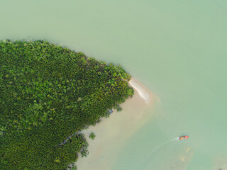 Aerial view of an island with fishing boat cruising passed it.